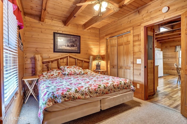 415 Silver Maple Ln, Gatlinburg, TN 37738 - carpeted bedroom featuring wooden walls, beamed ceiling, freestanding refrigerator, and wood ceiling