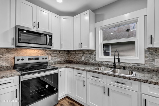 kitchen with a sink, stainless steel appliances, and white cabinetry