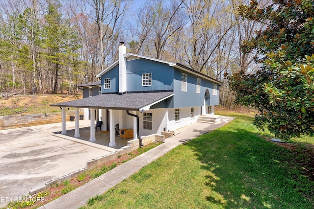 1606 Sexton Ln, Knoxville, TN 37932 - exterior space with roof with shingles, a chimney, a patio area, and a front lawn