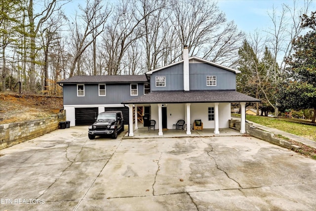 1606 Sexton Ln, Knoxville, TN 37932 - view of front of property with a porch, a chimney, a garage, concrete driveway, and a shingled roof