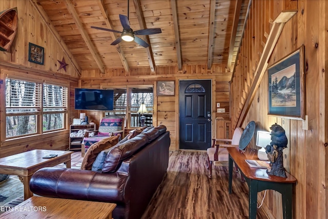 living area with vaulted ceiling with beams, wood walls, and wood ceiling