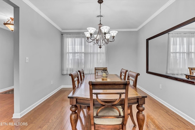 dining area with baseboards, a notable chandelier, ornamental molding, and wood finished floors