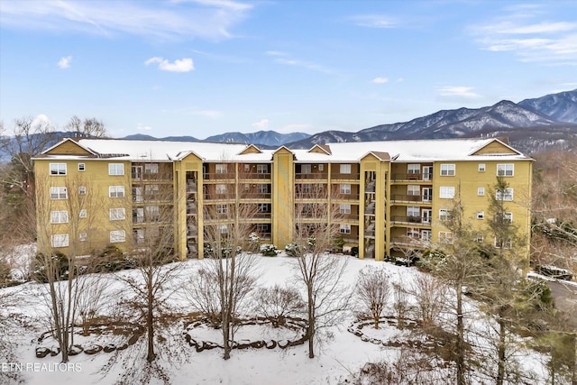 snow covered building featuring a mountain view