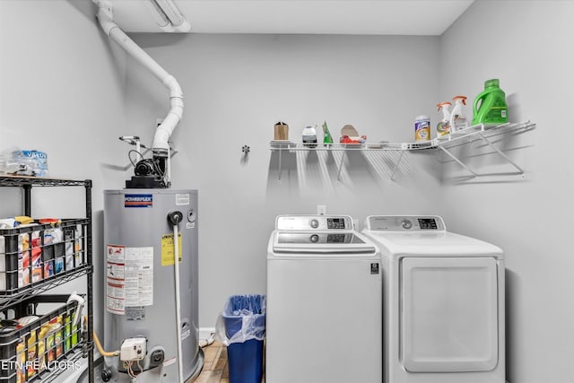 clothes washing area featuring separate washer and dryer, laundry area, and gas water heater