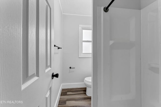 bathroom with toilet, baseboards, walk in shower, and wood finished floors