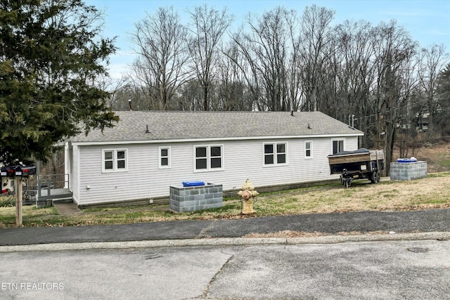 view of side of home with a shingled roof