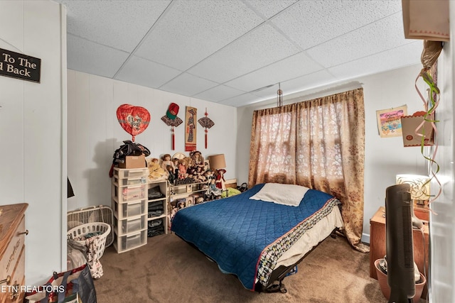 bedroom with carpet floors and a paneled ceiling