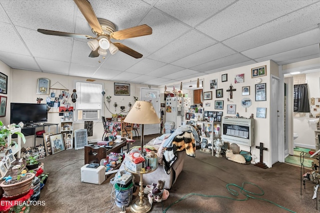 living room featuring carpet flooring, heating unit, and a paneled ceiling