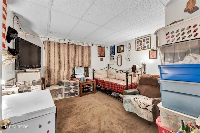 carpeted bedroom featuring a drop ceiling