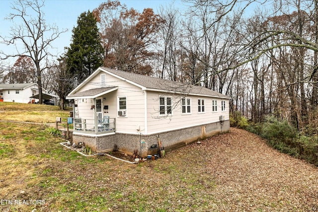 view of home's exterior featuring a lawn, brick siding, and roof with shingles