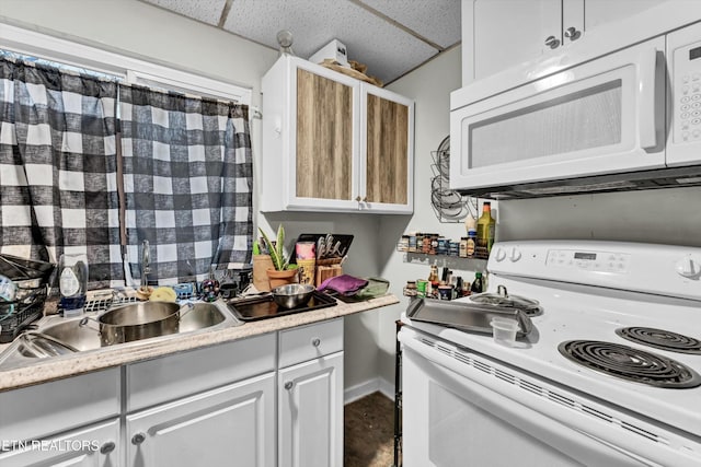565567 W Outer Dr, Oak Ridge, TN 37830 - kitchen featuring white appliances, baseboards, a drop ceiling, and light countertops