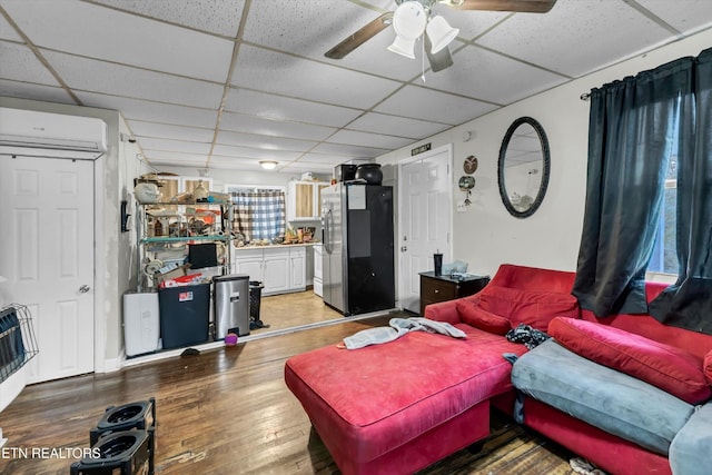 565567 W Outer Dr, Oak Ridge, TN 37830 - living area featuring ceiling fan, a wall mounted AC, light wood finished floors, and a paneled ceiling