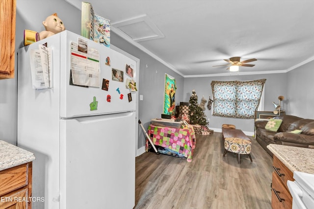 kitchen featuring crown molding, freestanding refrigerator, ceiling fan, and wood finished floors