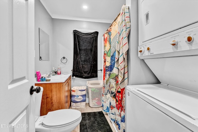full bathroom with vanity, crown molding, curtained shower, stacked washer / dryer, and toilet