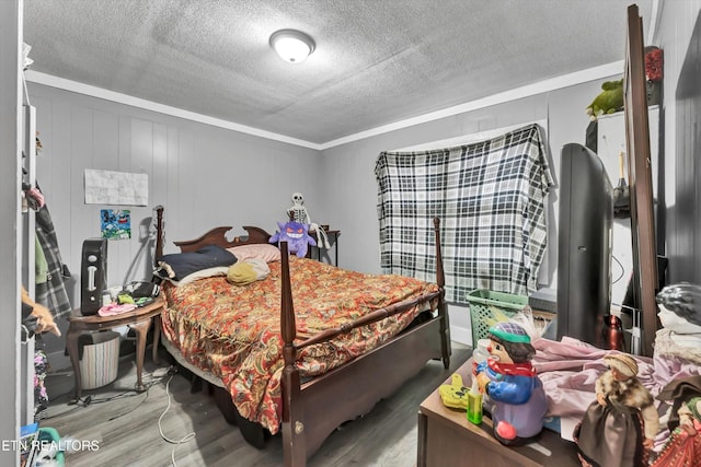 bedroom featuring crown molding, a textured ceiling, and wood finished floors