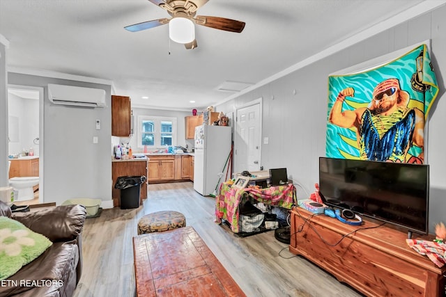 living area featuring ornamental molding, a wall unit AC, a ceiling fan, and light wood-style flooring