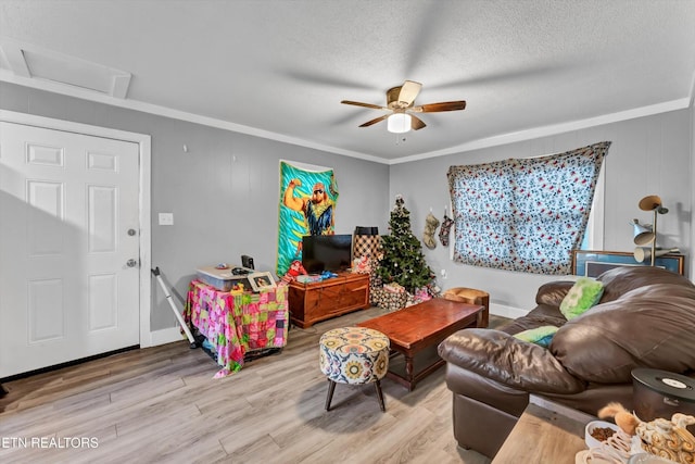 living area featuring crown molding, wood finished floors, baseboards, ceiling fan, and a textured ceiling