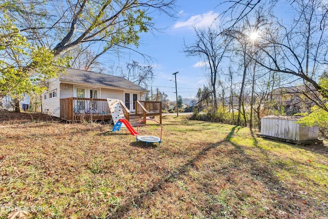 view of yard with a storage unit, an outdoor structure, french doors, and a deck