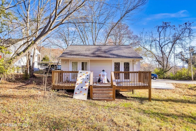 rear view of house with roof with shingles and a wooden deck