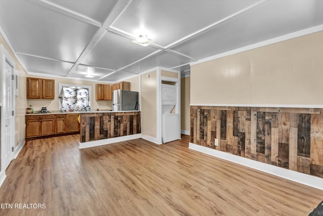 kitchen with light wood-style flooring, freestanding refrigerator, coffered ceiling, and brown cabinetry