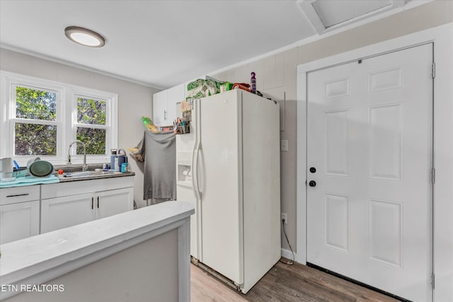 clothes washing area featuring a sink, wood finished floors, and attic access