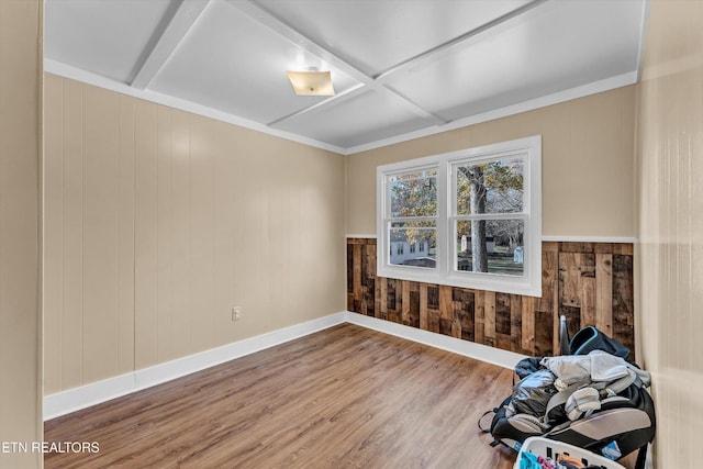 unfurnished room with wooden walls, baseboards, wood finished floors, and coffered ceiling