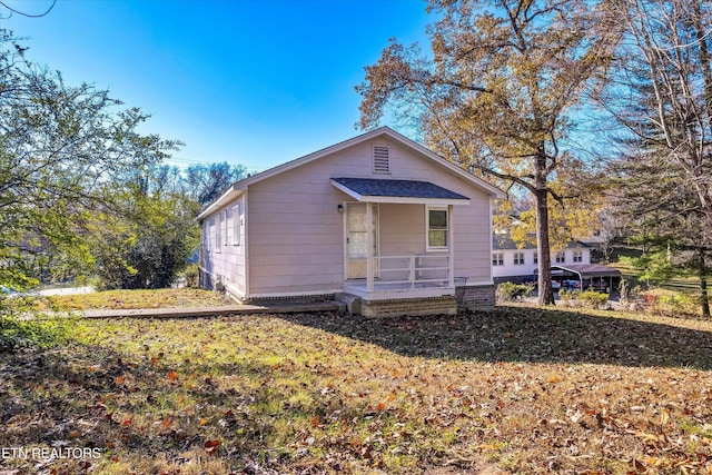 rear view of property with a porch and roof with shingles