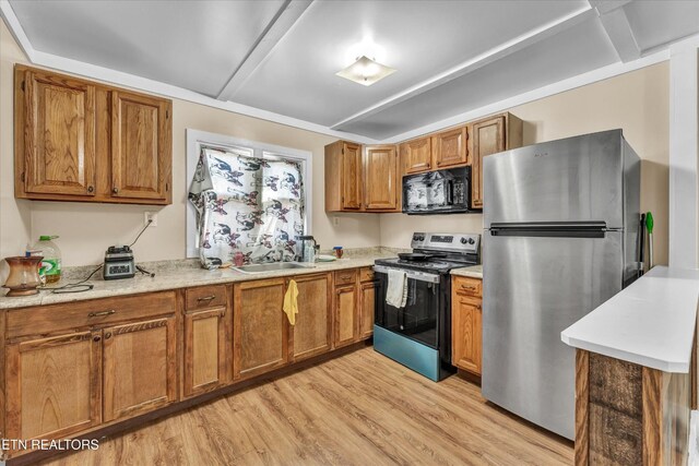 kitchen with a sink, appliances with stainless steel finishes, brown cabinets, and light wood-style flooring