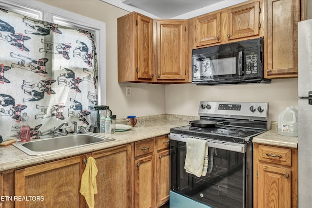 kitchen featuring black microwave, stainless steel electric range oven, brown cabinets, a sink, and light countertops