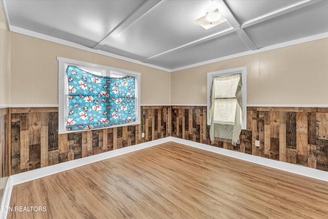 unfurnished room with coffered ceiling, wood finished floors, and wooden walls