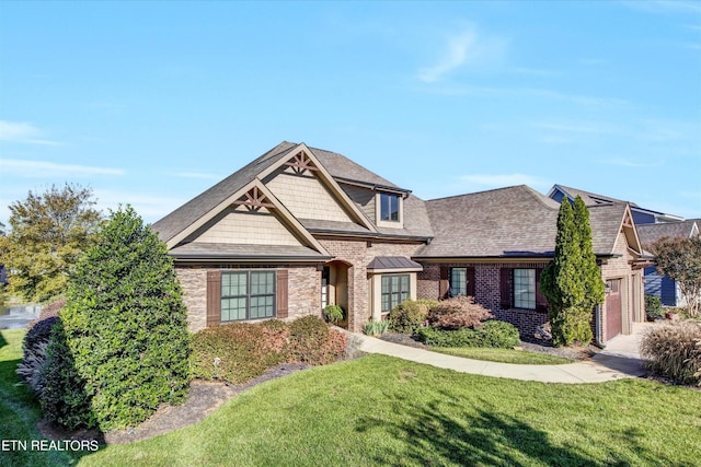 view of front of home with brick siding, a garage, roof with shingles, and a front yard