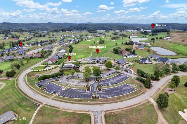 drone / aerial view with a residential view, view of golf course, and a water view