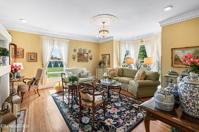 living area featuring plenty of natural light, ornamental molding, and wood finished floors