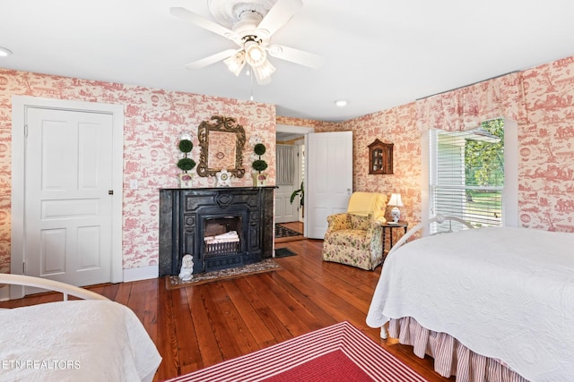 bedroom with wood-type flooring, a fireplace with flush hearth, recessed lighting, and wallpapered walls