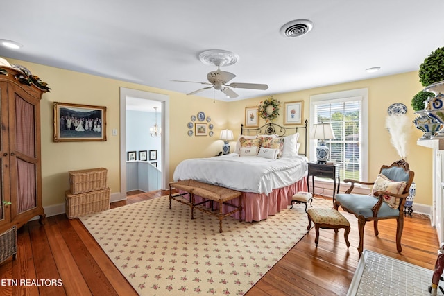 bedroom featuring baseboards, wood-type flooring, and visible vents