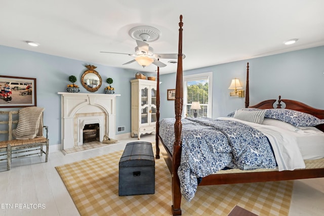 bedroom featuring ceiling fan, visible vents, and a fireplace