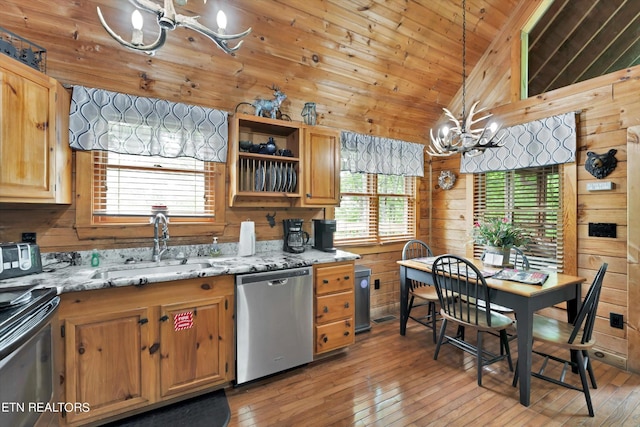 kitchen featuring dishwasher, a sink, lofted ceiling, an inviting chandelier, and light wood-style flooring