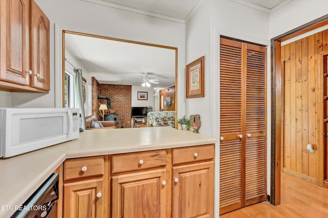 3178 N Clear Fork Rd, Sevierville, TN 37862 - kitchen with ceiling fan, a wood stove, light wood-type flooring, light countertops, and white microwave