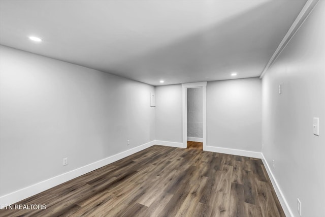 empty room featuring recessed lighting, baseboards, and dark wood finished floors
