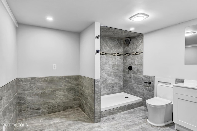 full bath featuring toilet, recessed lighting, tiled shower, and vanity
