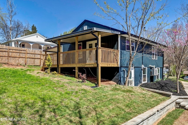 rear view of property with a lawn and fence