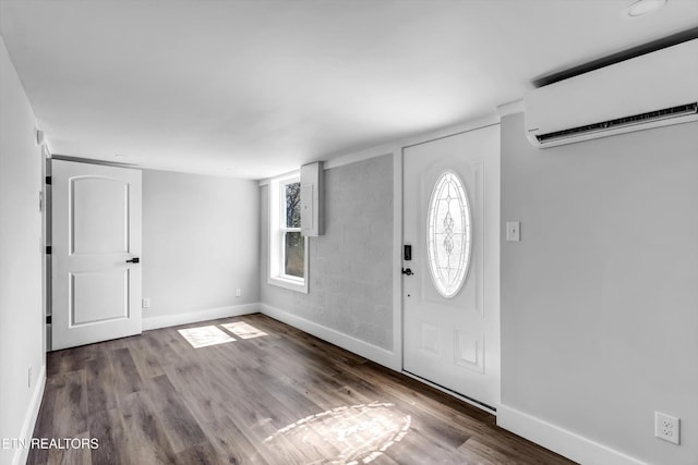 foyer with wood finished floors, baseboards, a wealth of natural light, and a wall mounted air conditioner