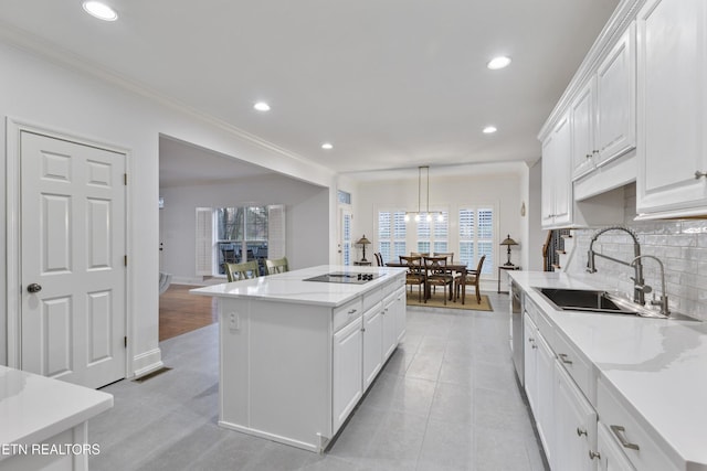 kitchen with a sink, a kitchen island, white cabinetry, and black electric cooktop
