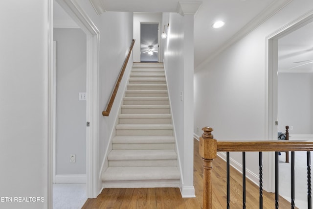 staircase featuring ceiling fan, crown molding, wood finished floors, baseboards, and recessed lighting