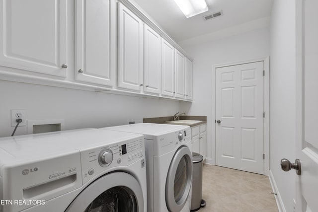 laundry room with cabinet space, a sink, baseboards, visible vents, and washing machine and dryer