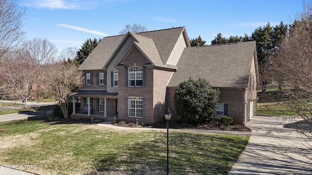 view of front of house featuring brick siding, driveway, and a front yard