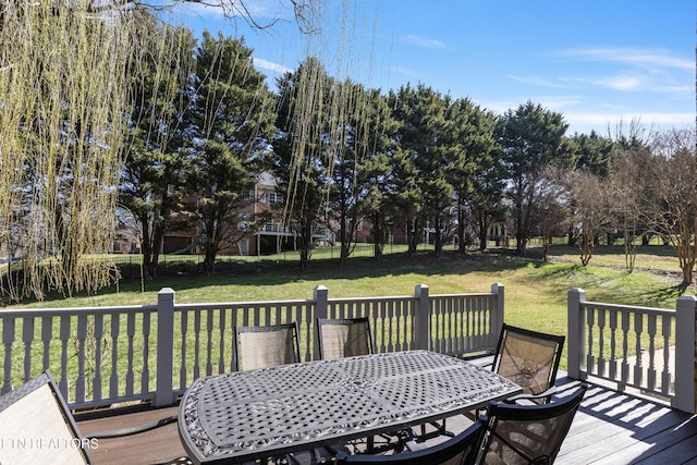 wooden deck with a lawn and outdoor dining space