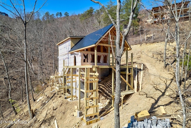 view of home's exterior with a wooded view and metal roof