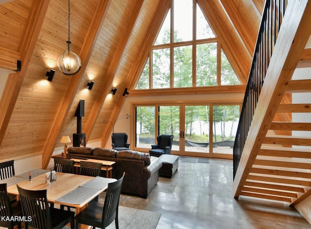 dining room with stairway, high vaulted ceiling, beamed ceiling, and concrete floors