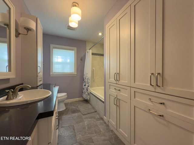 full bathroom featuring visible vents, vanity, toilet, baseboards, and tiled shower / bath